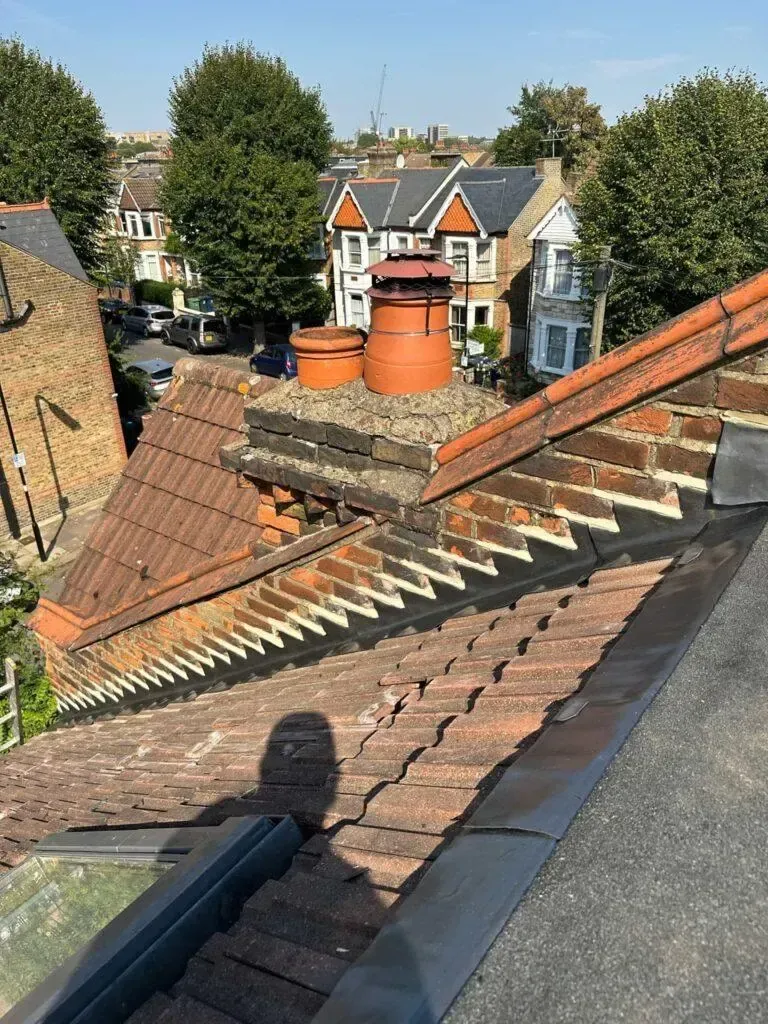 Ridge tiles re-bedded on a pitched roof near Brentford