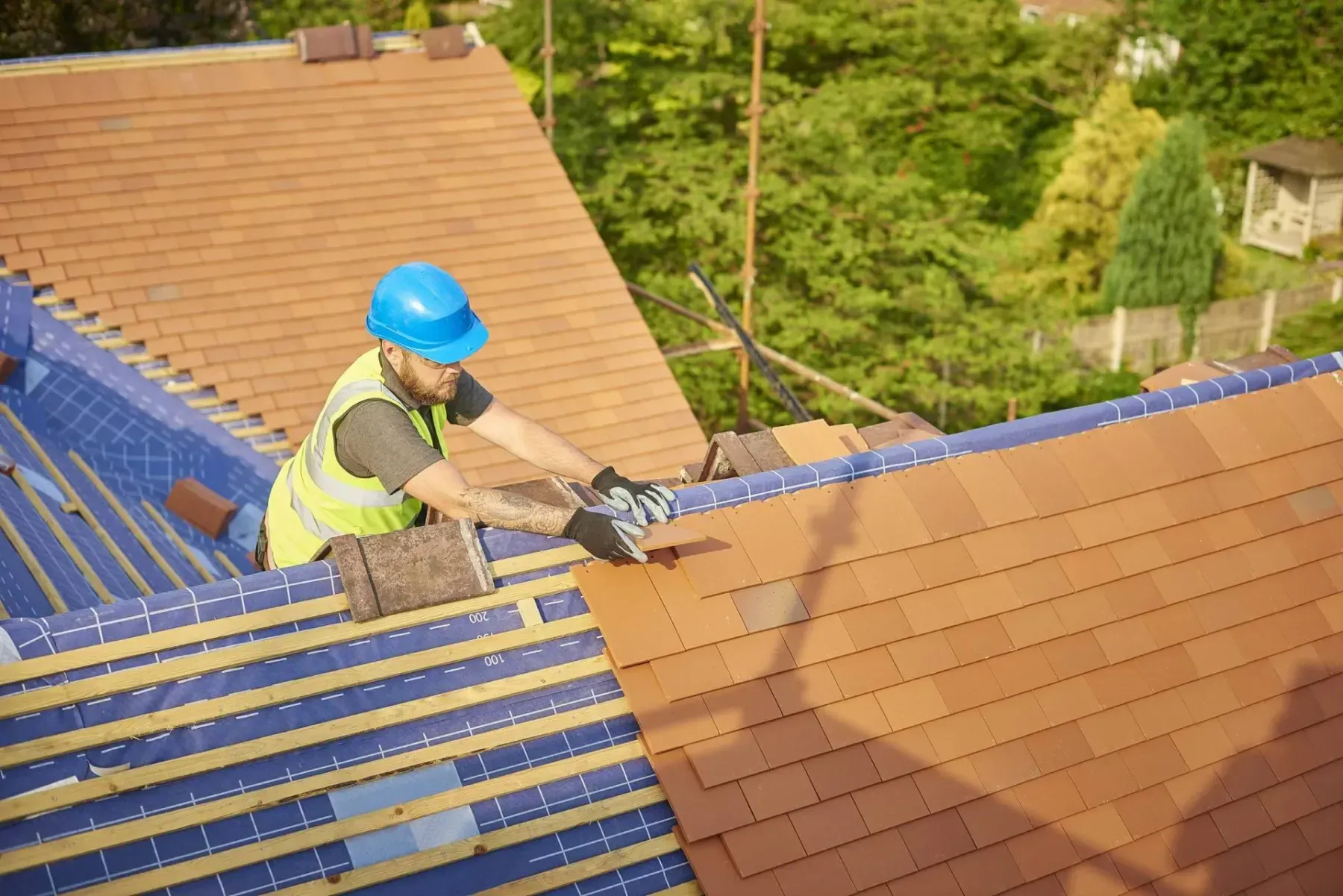 Roofer replacing a tiled roof as part of our roofing services in Brentford